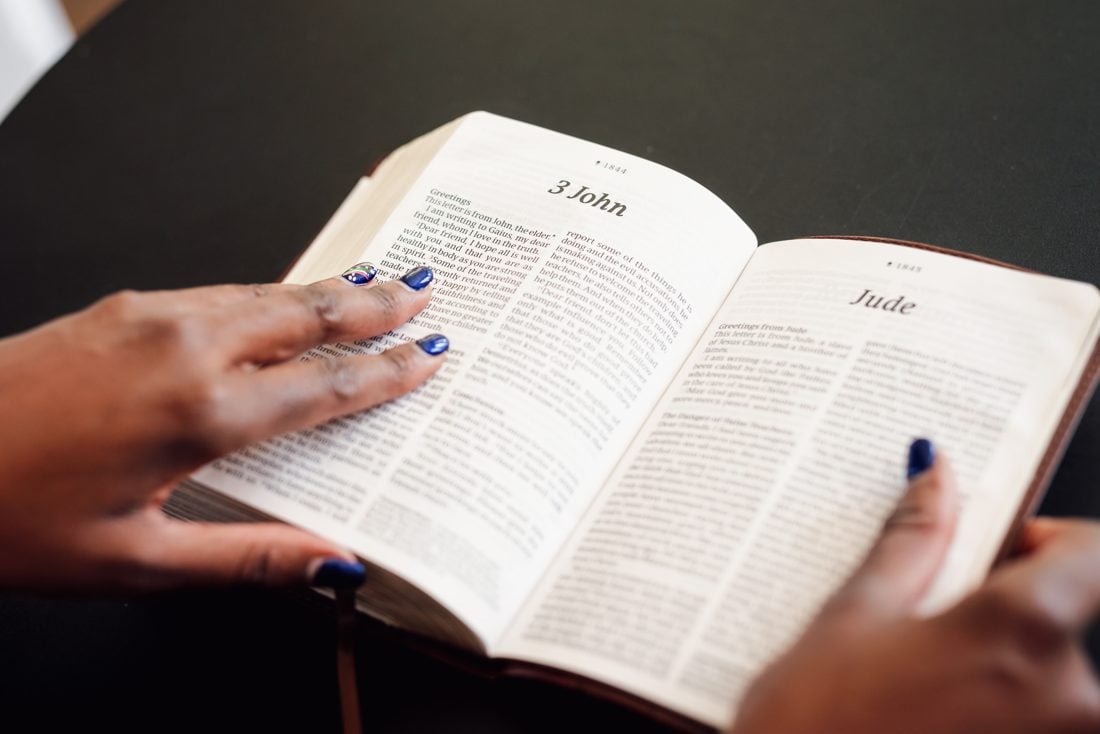 Hands resting on an open Bible